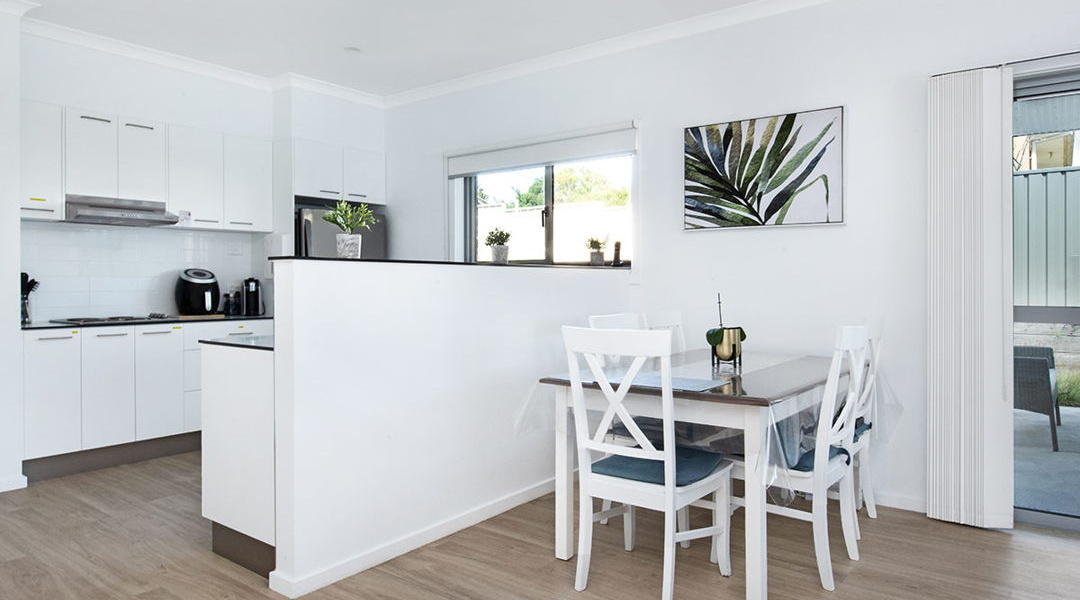 Kitchen vew and dining table with balcony door to the backyard