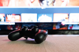 Video Game Controller in Front of a TV Screen